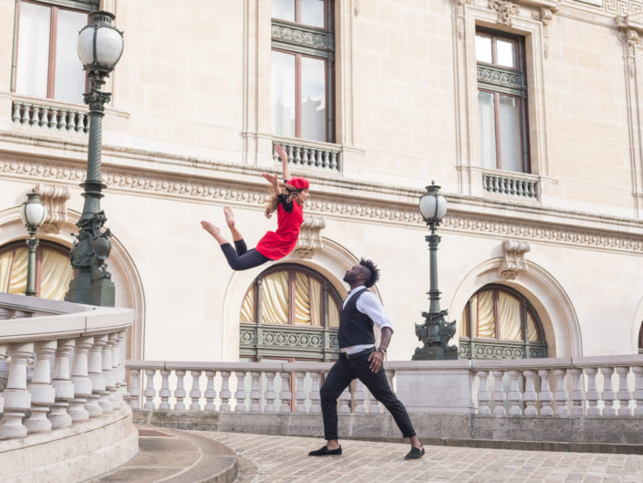 danseuse habillée en rouge effctuant un saut avec un danseur prêt à la réceptionner