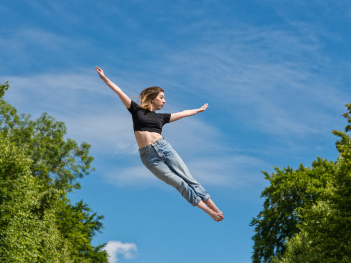 Danseuse effectuant un saut dans le parc de sceaux avec un beau ciel bleu