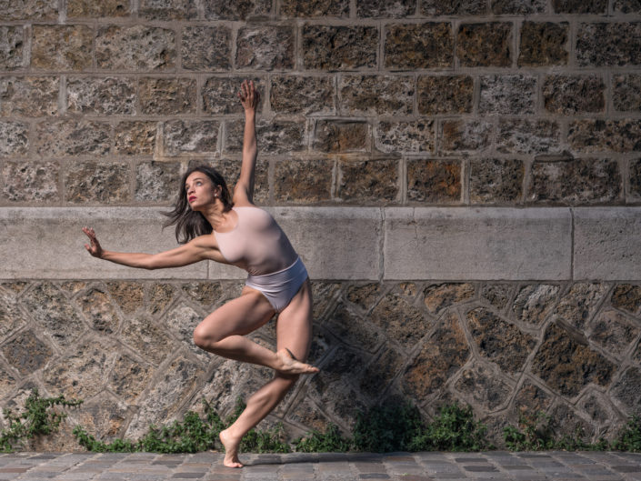 danseuse en mouvement devant un mur en pierre à montmartre