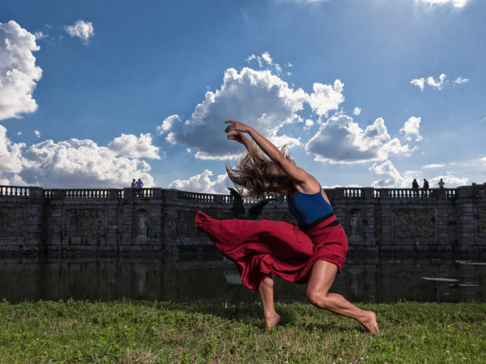 Danseuse justaucorps bleu jupe rouge en mouvement devant le chateau de fontainebleau