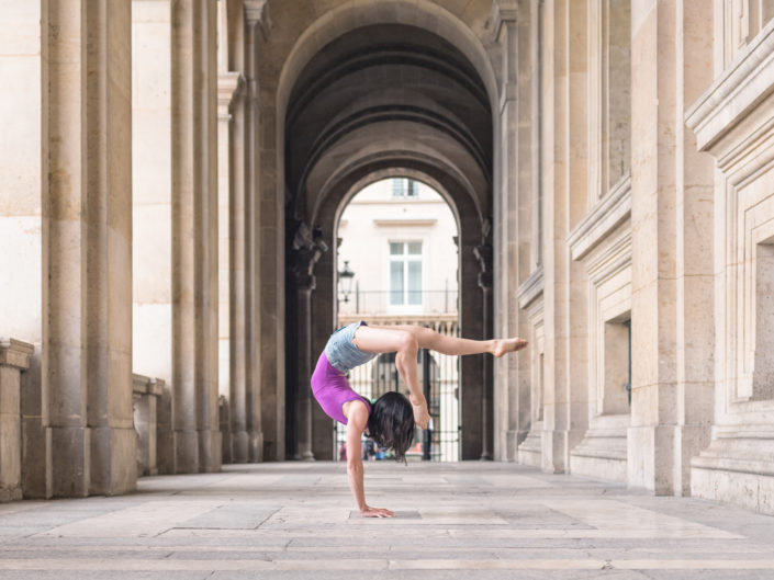 contortioniste en justaucorps rouge dans un passage au louvre