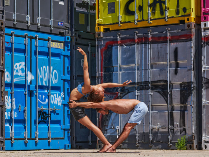 duo de yogi en position à pantin autour de conteneurs