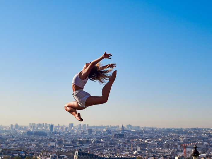 Danseuse contemporain qui effectue un saut devant le sacré coeur à montmartre à paris